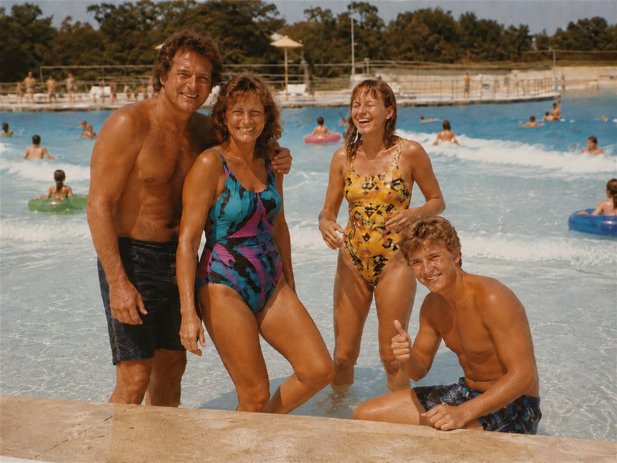 A smiling family posing on the edge of the wave pool in 1989